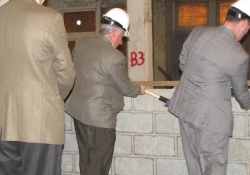 Senator Fontana, center, busts the wall to signify the beginning of construction for the Shanahan Apartments. 